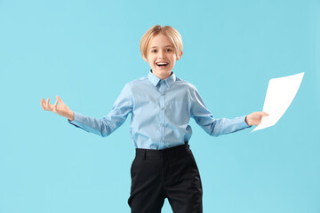 Little actor with film script on blue background