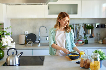 Portrait of a woman eating breakfast in the kitchen at home