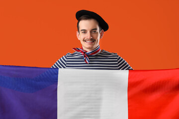 Handsome man with flag of France on orange background