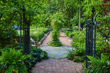 Black gate leading into Minnetrista Museum and Gardens with red brick path, Muncie Indiana