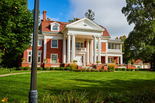 Maplewood mansion at Minnetrista Museum and Gardens with green lawn and blue sky