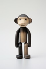 Fototapeta premium In minimalist detail, a small wooden monkey figure is black.