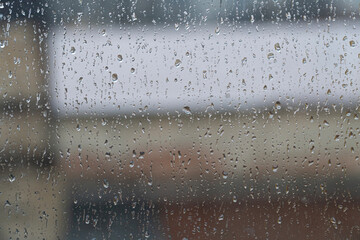 Raindrops on the window glass. Blurred background outside the window