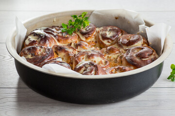 prepared baked sweet cinnabon with cream in a baking dish .