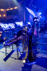 Wind instrument and music stands with orchestral notes in a concert hall