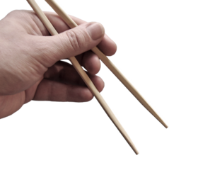 Asian chopsticks held in men hand. No food. No identifiable person. Cut out. PNG