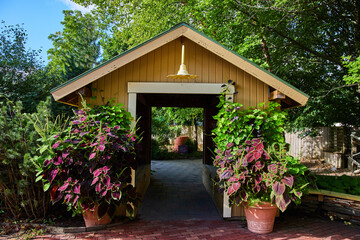 Potted plants outside storage shed with red brick road at Minnetrista Museum and Gardens
