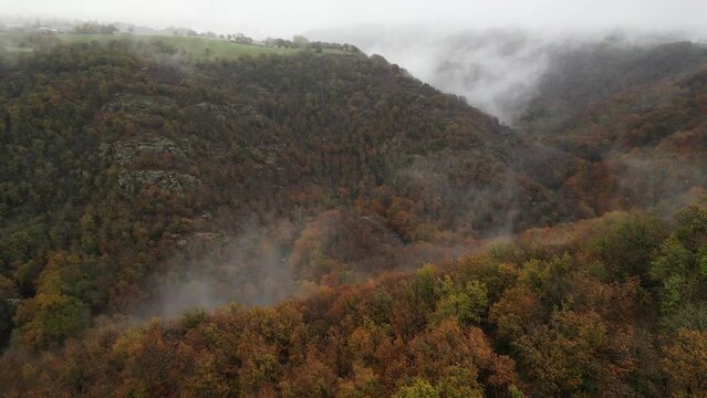 Fly over colorful autumn landscape over the hills of Aveyron