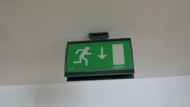 A green sign indicating the direction of the exit. This green sign serves as a directional guide, helping individuals navigate and locate the way to the exit. Safety and guidance in signage background