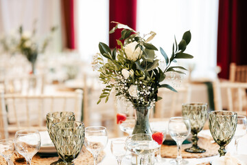 shot of the wedding hall decorated with flowers and lights, tables set with cutlery and beautiful decorations, wedding day