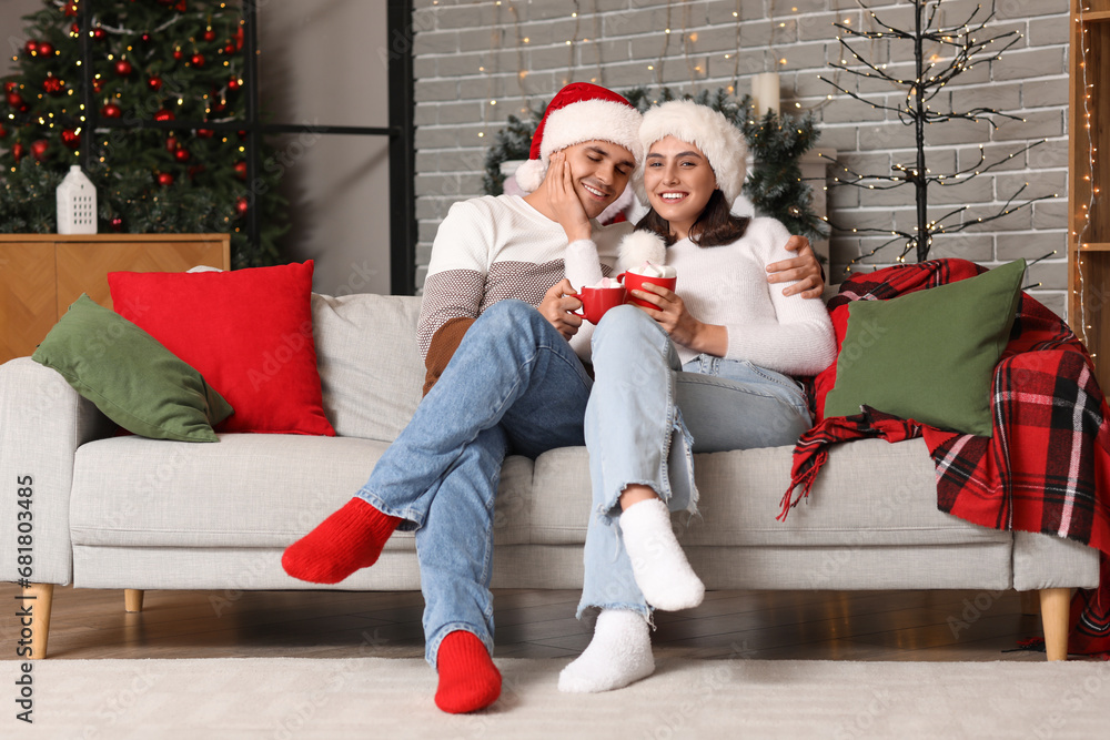 Sticker happy young couple drinking hot cocoa with marshmallows at home on christmas eve