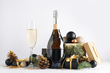 Composition with bottle of champagne, Christmas gifts and beautiful decorations on white background