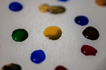multi-colored drops of water on a light sheet, background. Close up view