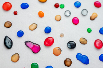 multi-colored drops of water on a light sheet, background. Close up view