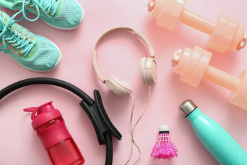 Set of sports equipment with headphones on pink background - obrazy, fototapety, plakaty