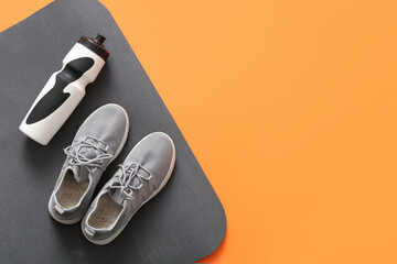 Pair of stylish sneakers, yoga mat and bottle of water on color background - obrazy, fototapety, plakaty
