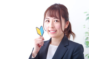 初心者マークをもつ笑顔の女性