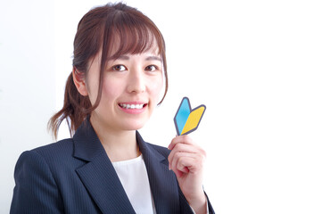 初心者マークをもつ笑顔の女性