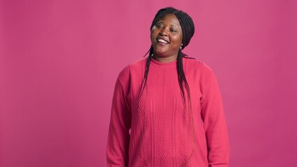 Video captures trendy african american beauty embracing pink sweater fashion, posing confidently...