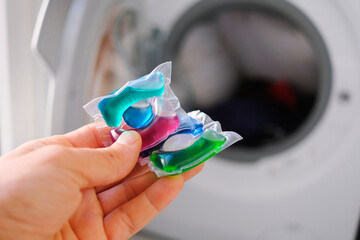 Washing machine detergent in pod form, with plastic that dissolves in water inside the washing...