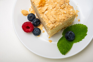 close up view, napoleon cake on light surface, white plate, side view. Place for inscription