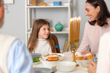 Obraz na płótnie Canvas Little girl having family dinner at home on Hanukkah