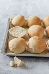 Appetizing fresh rolls on a tray and light gray background, homemade breakfast/meal concept, healthy food, close-up, minimalist.