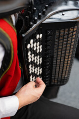 Accordion in the hands of a musician. Musical instrument.Musician playing the accordion, close-up.