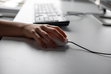 Close-up of a woman's hand using a mouse on a desk