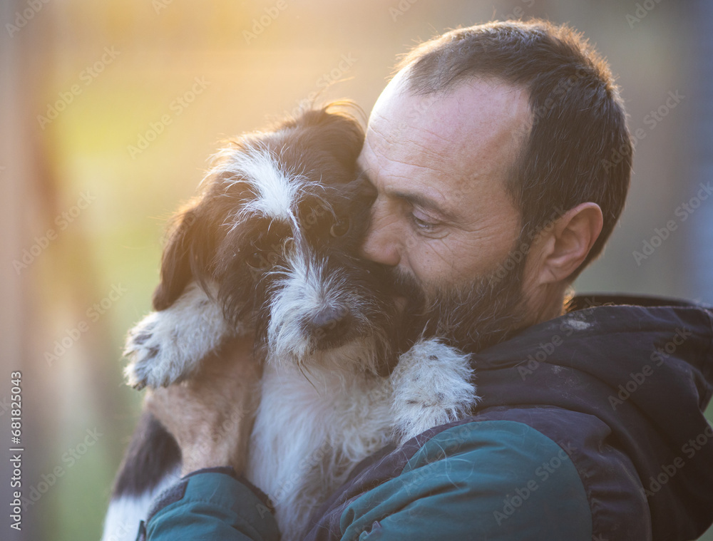 Wall mural man holding and hugging dog in shelter