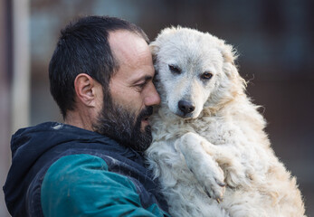 Man holding and hugging dog in shelter