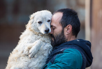 Man holding and hugging dog in shelter