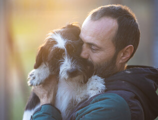Man holding and hugging dog in shelter