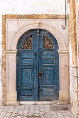 Fototapeta na wymiar A blue keyhole, or Moorish, arch door on a house near the Tunis Souk.