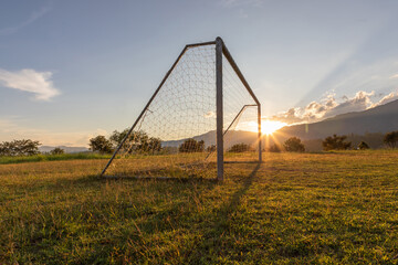 Soccer field in the countryside mountain sunset background.