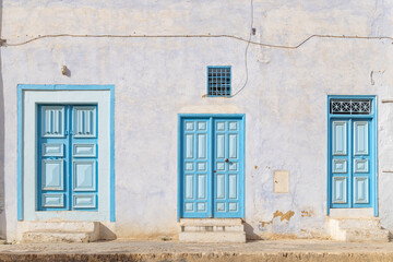 Blue doors in a white stucco building.