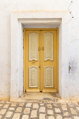 A yellow door in a white building.