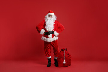 Santa Claus and bag of Christmas presents on red background