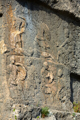 Closeup of reliefs carved in stone cliff near ancient Lycian rock tombs in Tlos city, Mugla Province, Turkey