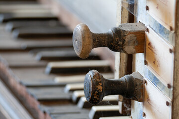 The close-up reveals worn, yellowed piano keys with intricate patterns and the faint remnants of...
