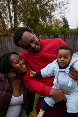 Fototapeta premium Pregant woman enjoying her garden with her son and husband