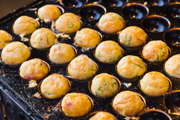 traditional takoyaki in a molded pan, takoyaki are ball-shaped Japanese snack