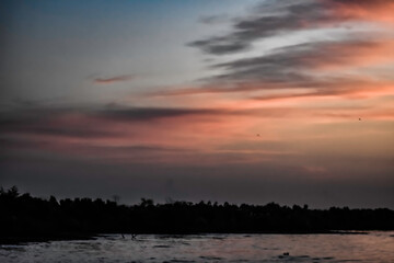 Fototapeta na wymiar orange clouds at sunrise over the lake