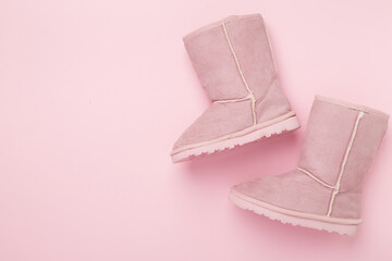 Beautiful childish ugg boots on color background,top view