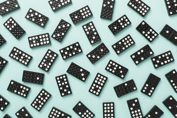 Black domino tiles on color background, top view