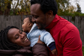 Fototapeta premium Beautiful African family enjoying their autumnal garden