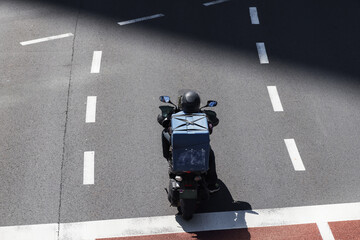 aerial view of a motorcycle courier in city traffic
