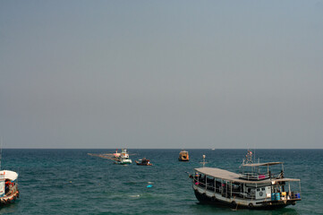 Many fishing boats in the middle of the sea are hunting fish.