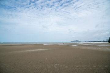 The sea at low tide reveals a wide expanse of sand.