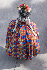 Colorfully dressed Catrina participant parades down a street 
